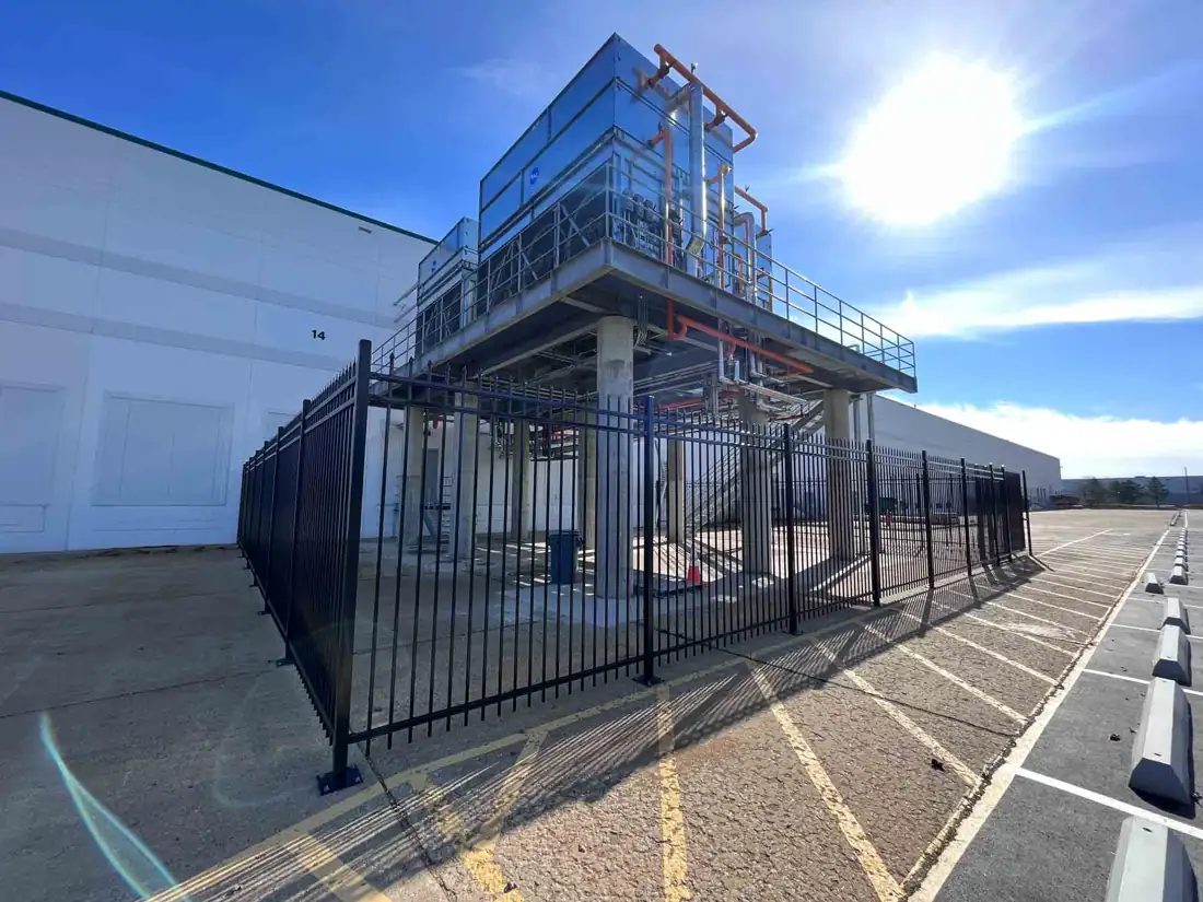 Black steel fence enclosing rooftop mechanical equipment at a commercial building