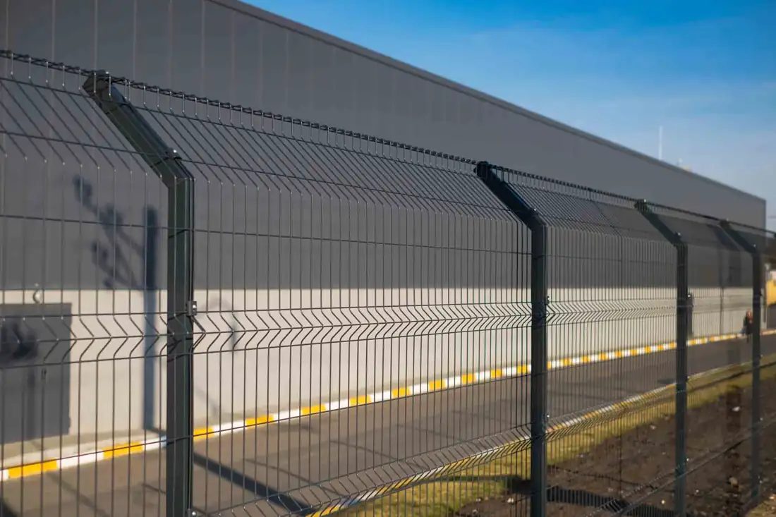 Welded wire mesh security fence along a warehouse